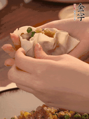 取一大勺餡料放進餃子皮里，用大拇指按住頂部餡料，再用虎口掐出形狀。
